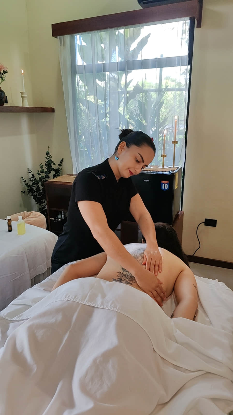 Terapeuta de Reborn Spa trabajando la espalda de una clienta con las dos manos